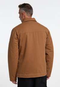 Brun, polstret jakke med spidse kraver og sidelommer. Regular fit, med synlige sømme og en glat, holdbar stoftekstur.