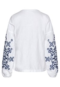 Weiße Leinenbluse mit langen, puffäugigen Ärmeln, die mit aufwendiger, marineblauer floralem Stickerei an den Ärmeln verziert ist und einem runden Ausschnitt.