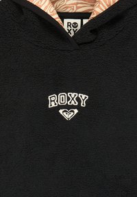 Černá fleece mikina s texturovaným povrchem, s bílým logem "ROXY" a designem srdce, a vzorovanou podšívkou v broskvové a krémové barvě.