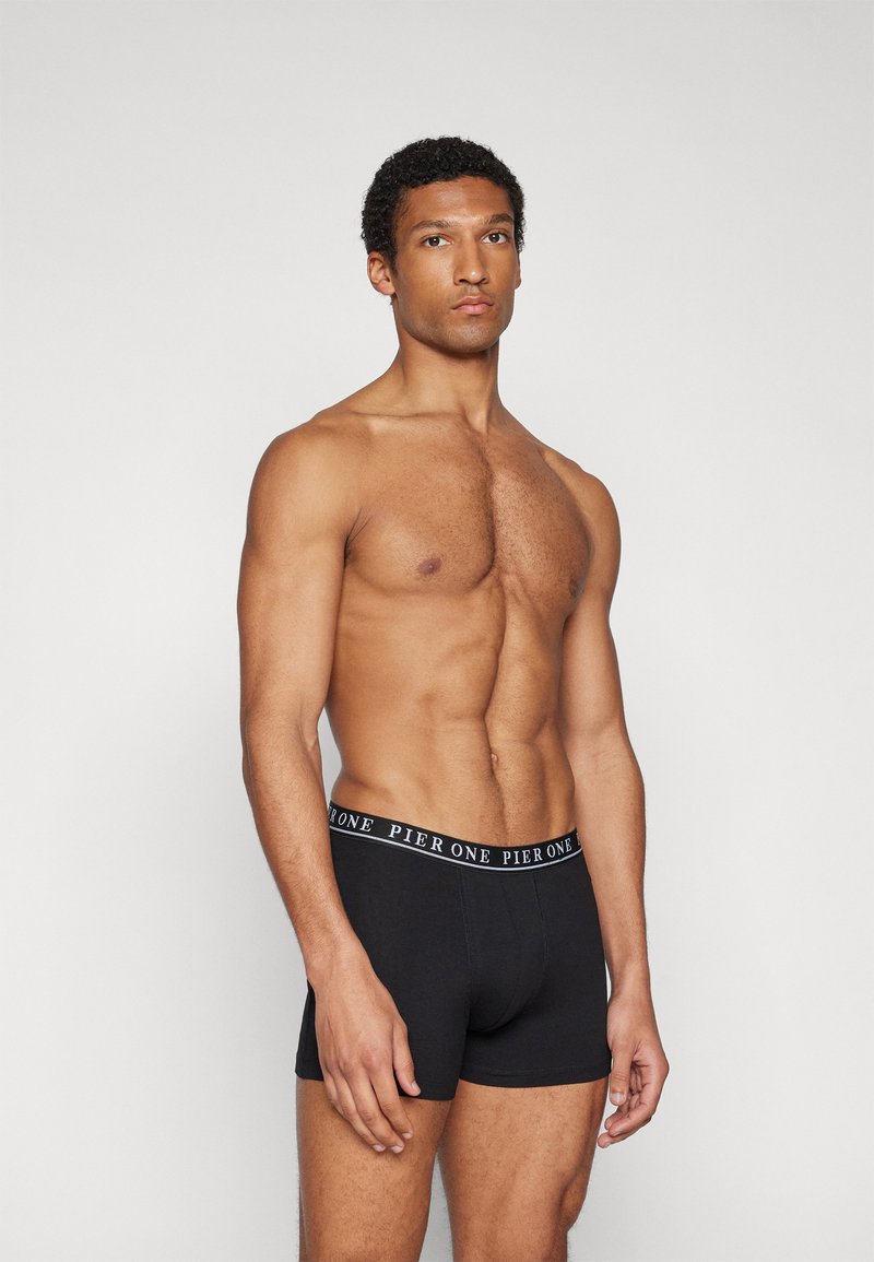 Boxers noirs avec un design ajusté, dotés d'une taille élastique avec le logo "PIER ONE". Texture lisse, style minimaliste.