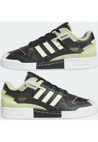 Svarta och ljusgröna sneakers i läder och mocka, med tre ränder, vit sula och röda detaljer. Guldlogotyp på sidan.