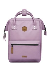 Sac à dos en tissu lavande avec double poignée, poche zippée à l'avant, écusson logo et fermeture éclair noire contrastante. Texture lisse avec des accents minimaux.