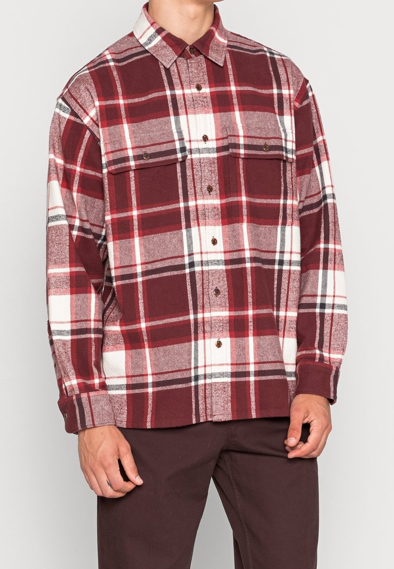 Rød og hvidternet flannel skjorte med lange ærmer, to brystlommer og knaplukning, der har en afslappet pasform og blød tekstur.