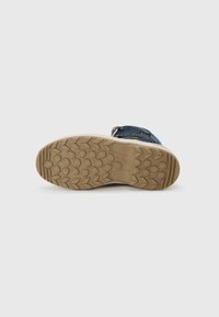 Beiger Gummisohle mit strukturiertem Profil und einem blauen Wildleder-Obermaterial, das mit einem Klettverschluss für einen sicheren Sitz versehen ist; langlebiges und flexibles Design.