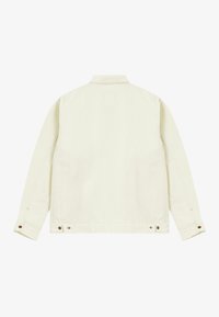 Veste en denim couleur crème avec un col, des manches longues et des détails sur les coutures latérales. Équipée de boutons métalliques aux poignets et à l'ourlet.