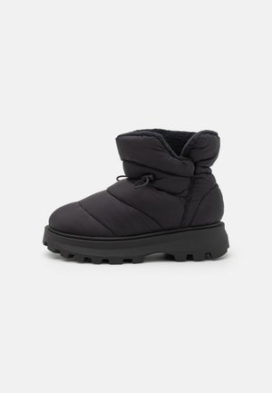 Black insulated ankle boots with a puffy quilted design, rubber sole, and a foldable cuff. Features a drawstring for a snug fit.