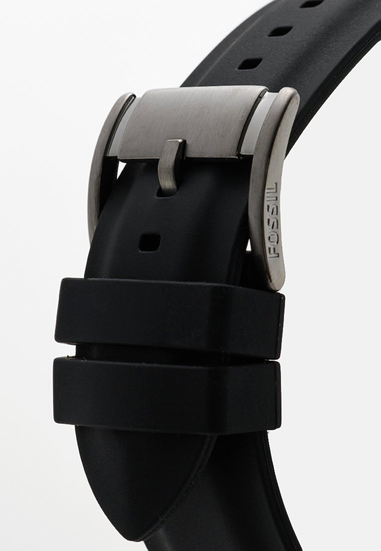 Cinturino per orologio in gomma nera con fibbia in metallo spazzolato argentato, dotato di più fori per la regolazione e una superficie liscia e opaca.