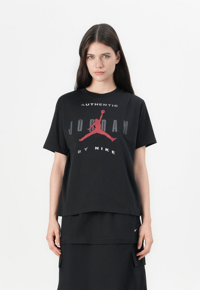 Černé bavlněné tričko s velkým červeným a šedým logem Jumpman a tučným nápisem "Autentický Jordan od Nike". Krátké rukávy, volný střih.