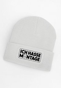 Gray knitted beanie with a prominent black and white patch. The patch features a cat illustration and the text "ICH HASSE MONTAGE."