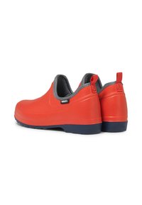 Bottes de chevilles étanches rouges avec une finition en plastique lisse, doublure intérieure grise, tirant pour un enfilage facile et semelle extérieure bleue pour une meilleure traction.