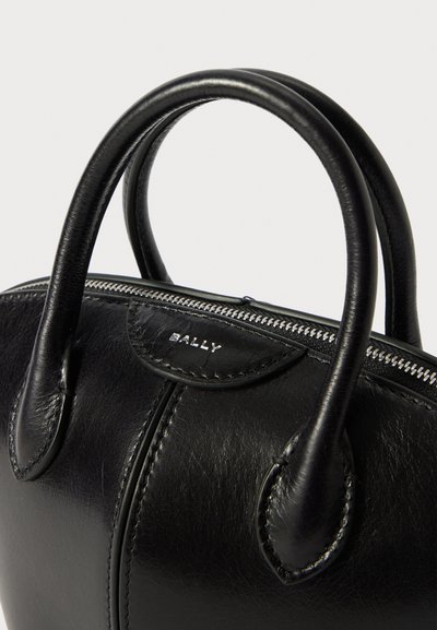 Sac à main en cuir noir avec des poignées arrondies, fermeture éclair et détail de logo en relief. Texture lisse et accents de coutures subtils.