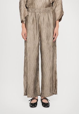 Wide-leg pants in a metallic taupe color, featuring a textured crinkled pattern and an elastic waistband. Black flat shoes with bow accents.
