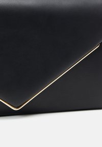 Pochette en cuir noir de style enveloppe avec un accent métallique doré le long du bord, présentant une texture lisse.