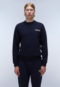 Marineblauwe sweatshirt met ronde hals, ribgebreide manchetten en zoom. Heeft een logo op de borst. De stof lijkt glad en heeft een effen kleur.