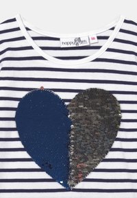 Randig t-shirt med rund halsringning. Har en stor hjärtformad design av blå och flerfärgade paljetter på framsidan.