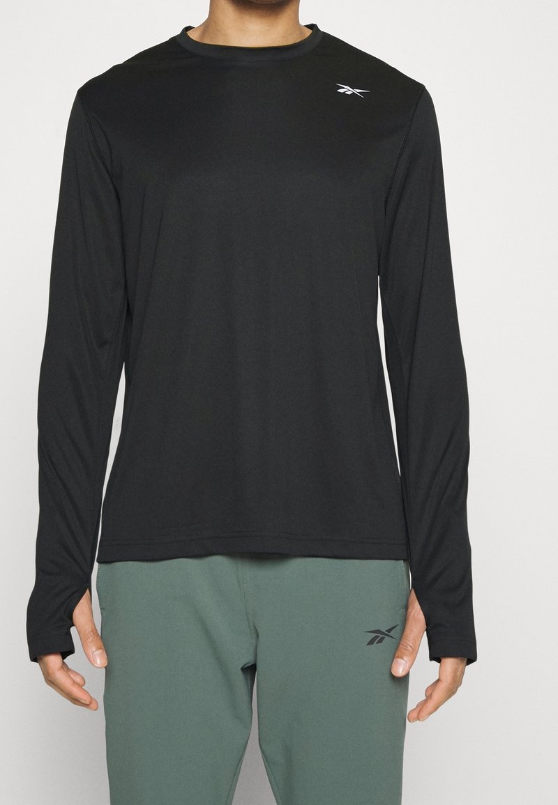 Svart långärmad träningströja med rund halsringning, tillverkad av lätt material. Har en liten logotyp på bröstet och tumhål i ärmarna.