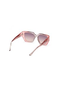 O pereche de ochelari de soare cu o ramă hexagonală, plastic clar cu gradient roz, lentile gri cu gradient și brațe subțiri transparente.