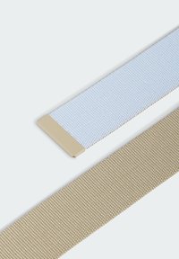 Dos correas entrelazadas: una en azul claro con un extremo beige liso, la otra en beige con una superficie texturizada.