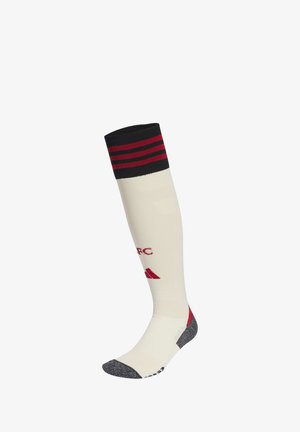 White knee-high sports sock with black and red stripes at the top and red lettering and logo on the calf.