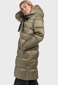 Lungo cappotto imbottito in verde oliva, design trapuntato con cappuccio, tasche con zip e cordini neri a contrasto. Tessuto liscio e lucido.