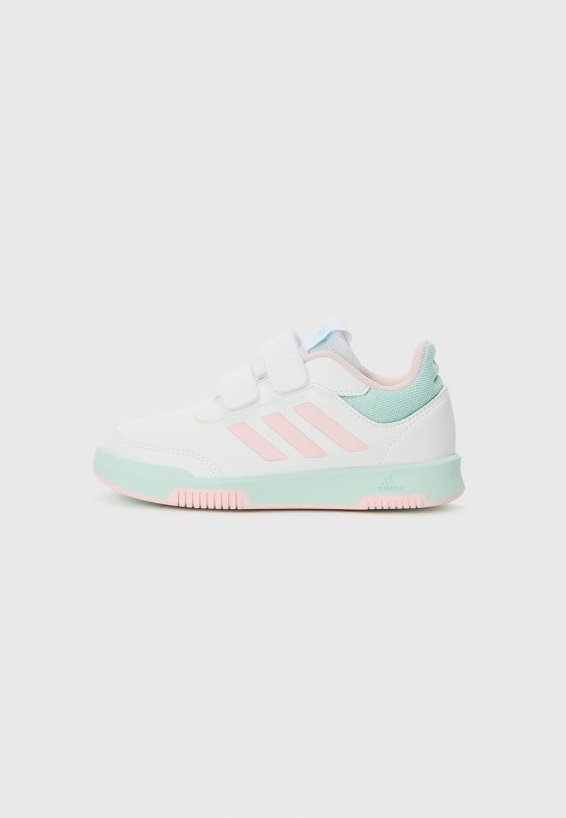 Chaussure de sport blanche avec des accents roses et vert menthe, dotée d'une tige en synthétique, de deux bandes Velcro et d'une semelle extérieure texturée.