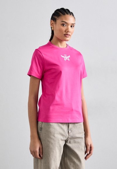 Tricou roz din bumbac cu decolteu rotund și mâneci scurte. Prezintă detalii cu un logo alb pe piept. Textură netedă. Asortat cu pantaloni bej.