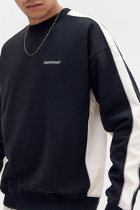 Schwarzer und cremefarbener Color-Block-Sweatshirt mit geripptem Halsausschnitt und Bündchen, ausgestattet mit einem kleinen gestickten "IETSFRANS"-Logo auf der Brust.
