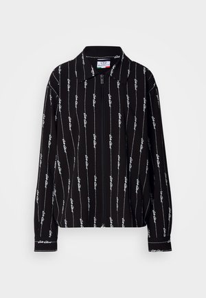 Sort skjorte med lange ærmer og krave, med et hvidt skriptmønster og lodrette linjer, tekstureret stof og knapped Manschetter.