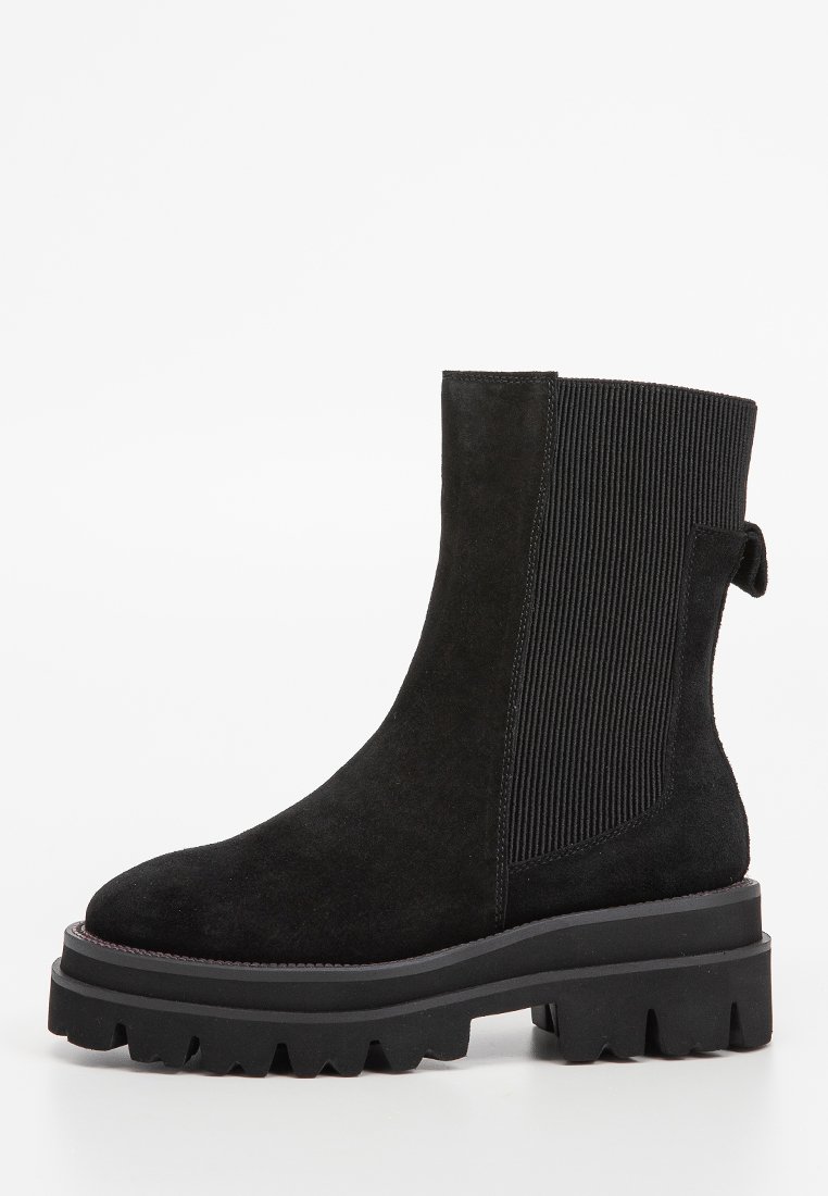 Stivale alla caviglia in suede nero con suola robusta a rilievo, pannello laterale elastico a coste e linguetta sul retro per una facile calzata.