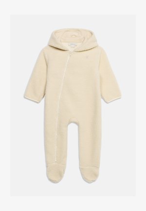 Hættebabyheldragt i cremefarve med lange ærmer, indbyggede fødder og asymmetrisk lynlås foran.