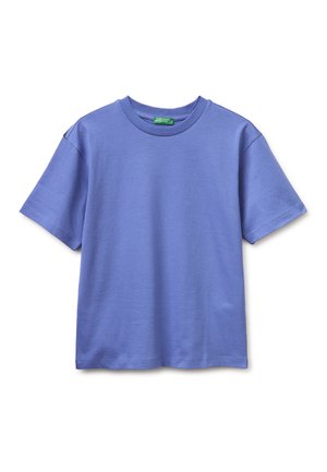 Camiseta lisa de manga corta y cuello redondo en azul claro, extendida plana con costuras visibles y una etiqueta de marca verde en el cuello.