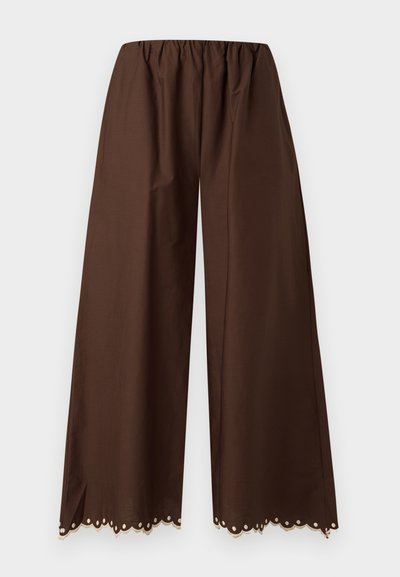 Καφέ παντελόνι με φαρδιά μπατζάκια, ελαστική μέση και διακοσμητικό δαντελένιο τελείωμα με κυματιστά σχέδια στο κάτω μέρος, πάνω σε λευκό φόντο.