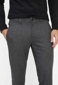 Grijze, gestructureerde broek met een aansluitend ontwerp, sluiting met knoop, voorzakken en een vlakke voorkant voor een nette uitstraling.