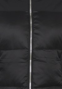 Giacca a vento nera con zip argentata lucida, texture trapuntata e tessuto liscio. Progettata con un colletto alto e area spalle senza cuciture.