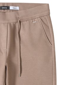Beige textuurbroek met een tailleband met trekkoord, schuine Franse zakken en een klein metalen merkembleem vlakbij de zak.