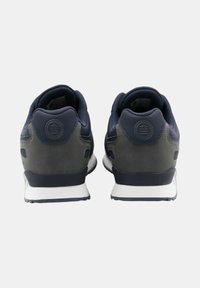 Marinblå och olivgröna sportskor med en texturerad ovandel, förstärkt häl, vit mellansula och gummiyttersula. Minimalistisk design, tvåfärgad färgsättning.