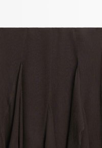 Bruin, geplooid stof met een gestructureerd oppervlak, voorzien van verticale lijnen en subtiele stikdetails, gerangschikt in vloeiende lagen.