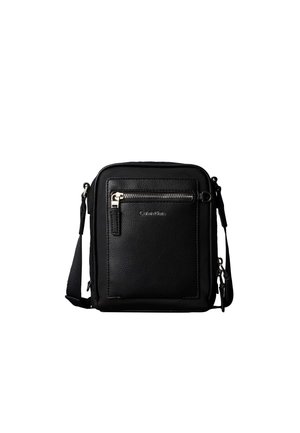 Schwarze Leder-Calvin-Klein-Umhängetasche mit vorderer Reißverschlusstasche und verstellbarem Schultergurt vor weißem Hintergrund.
