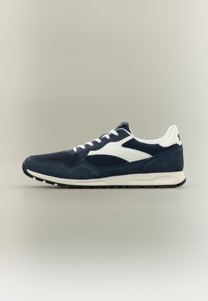 Marineblaue und weiße Sportschuh mit Mesh- und Wildleder-Obermaterial, weißen Schnürsenkeln und schwarzer Gummisohle, seitlich auf neutralem Hintergrund dargestellt.