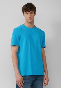 Lichtblauw T-shirt met korte mouwen en een ronde halslijn, gemaakt van zachte katoen. Heeft een klein logo op de borst en een relaxte pasvorm.