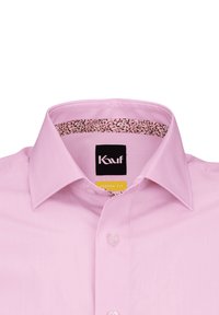 La camicia da uomo di colore rosa chiaro presenta un fit moderno, chiusura a bottoni e una rifinitura a fiori all'interno colletto. L'etichetta mostra il nome del marchio.