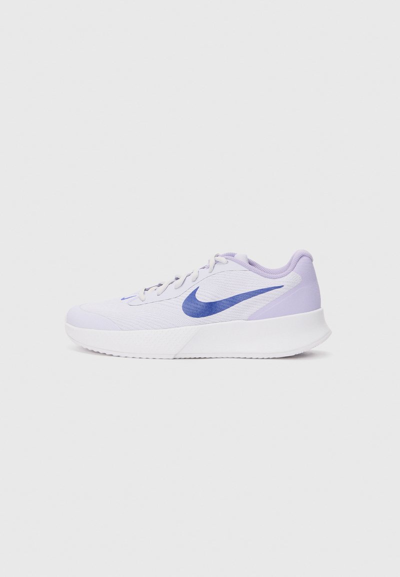 Baskets de sport lilas clair avec un dessus en maille texturée, semelle blanche et un logo Nike en violet foncé sur le côté. Design à lacets avec un col rembourré.