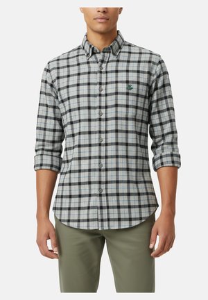 Camisa de cuadros en gris y negro con acentos azules. Tiene mangas largas, un collar y un logo bordado verde en el pecho.