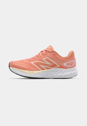 Leichter Laufschuh in Koralle mit einem atmungsaktiven Mesh-Obermaterial, weißer Dämpfungsmittelsohle und strukturiertem Gummiaußensohle. Modell 680.