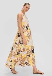 Maxikleid in einem Blumenmuster mit Gelb-, Braun- und Schwarztönen. Leichter Stoff mit gerafftem Taillenbund und fließendem, gestuftem Saum.