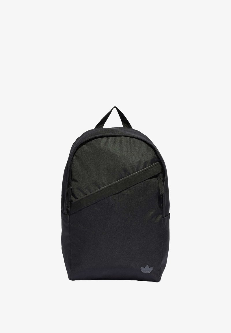 Black fabric backpack with a rounded shape, featuring a front zip pocket, top handle, and a subtle logo accent on the bottom right.