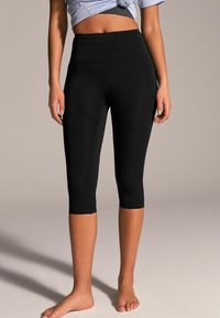 Svarta capri leggings med hög midja, tillverkade av ett mjukt och stretcht material. Har en åtsittande design som slutar strax nedanför knäet.