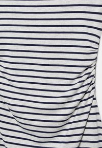 Tissu gris clair avec des rayures horizontales bleu marine foncé espacées uniformément et de légers plis naturels dans le matériau.