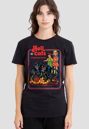 Woman wearing a black T-shirt with a graphic showing three black cats with red eyes and flames, two girls in vintage clothes, and text "Hell cats."