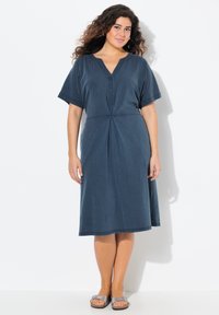 Tummansininen mekko, jossa on lyhyet hihat, V-pääntie, napitettu etuosa ja A-linjainen muoto; valmistettu pehmeästä kankaasta, jossa on hieno kiilto.